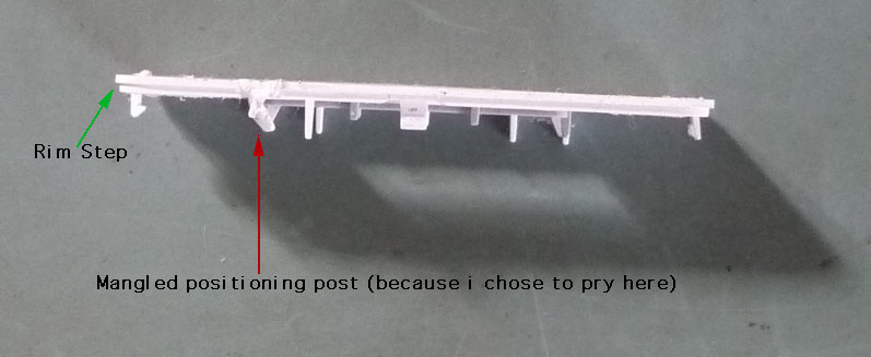 The rim step is about halfway across the thickness of the bottom plastic piece. Prying near the 1/3 or 2/3 points of the long edges will mangle positioning posts.
