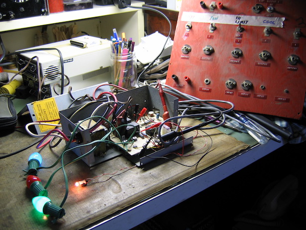 Control board in its enclosure with 4 attached incandescent lamps and a repurposed switch panel.