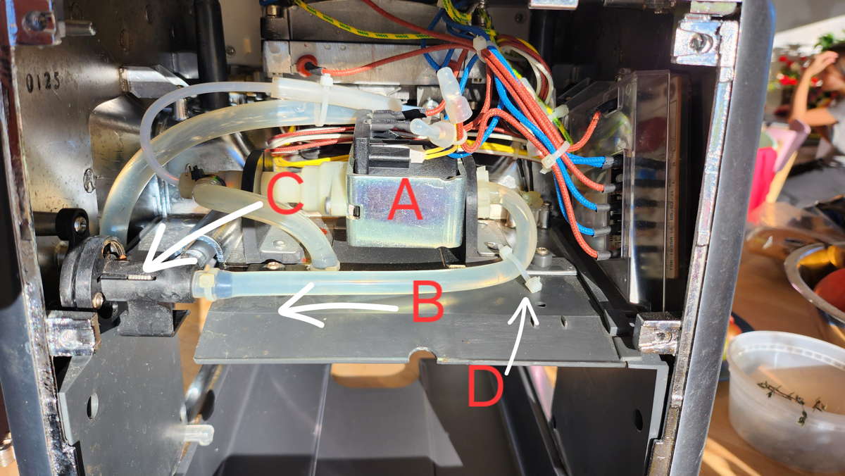 Photo of the parts described in the following paragraph, showing a tie wrap very near the pump end of the tank to pump hose wrapped around this hose and attached to the adjacent plastic panel.