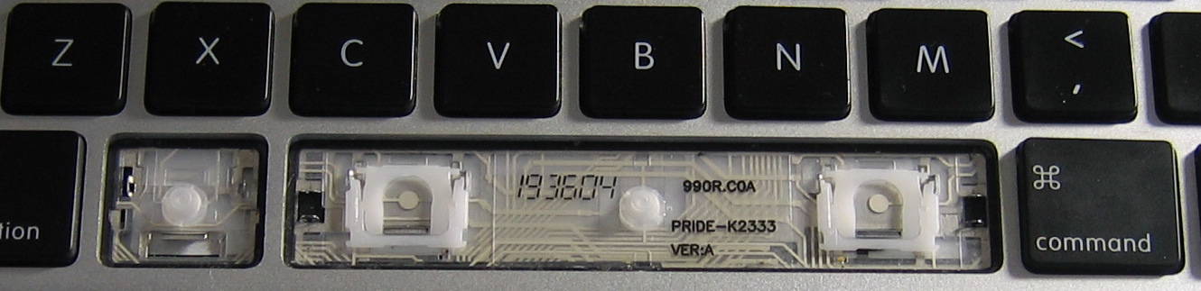 close-up of installed keyboard with left Command and space bar key caps removed. Nomenclature under the space bar: 193604 990R.C0A PRIDE-K2333 VER:A